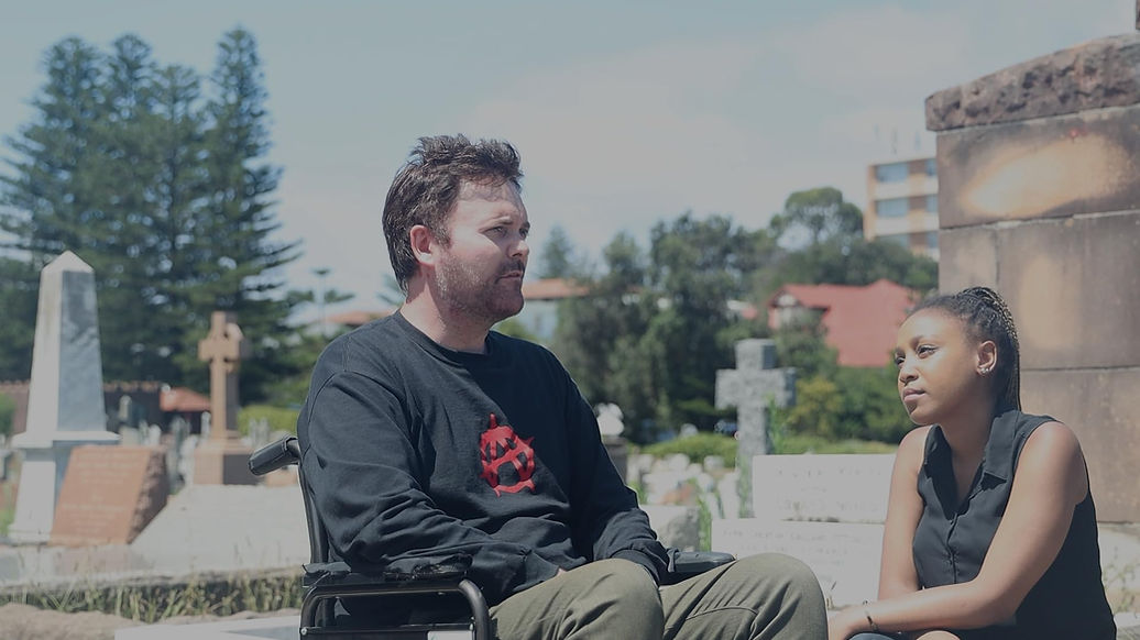 A man in a wheelchair in a graveyard